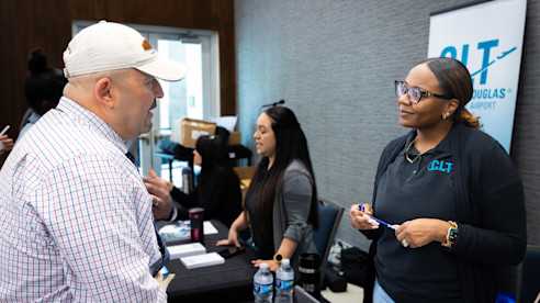 CLT Airport Job Fair attendee speaks with a recruiter about career opportunities and employment benefits.