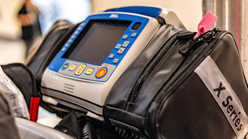 Portable defibrillator mounted on a cart inside the airport terminal.