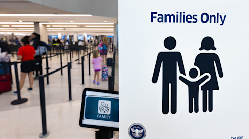 TSA checkpoint sign for “Families Only” with families walking through designated security lane.