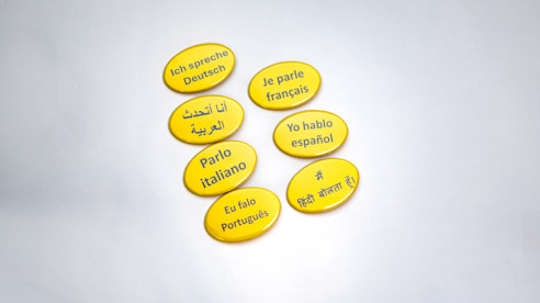 Botones amarillos que muestran distintos idiomas hablados, como español, francés, alemán, italiano y mandarín.