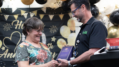 Janice Futrell smiles while receiving a plaque during her 50-year anniversary celebration.