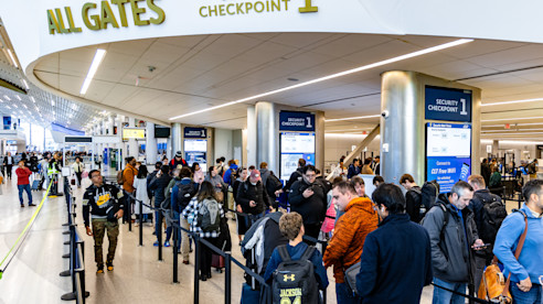 Pasajeros esperan en una fila larga en el Punto de Control de Seguridad 1 para todas las puertas del aeropuerto.