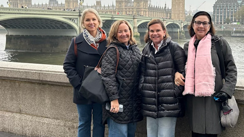 Four women posing by Big Ben and Houses of Parliament.