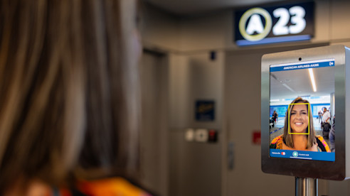 Facial recognition screen at airport gate A23 showing a passenger’s face during identity verification.