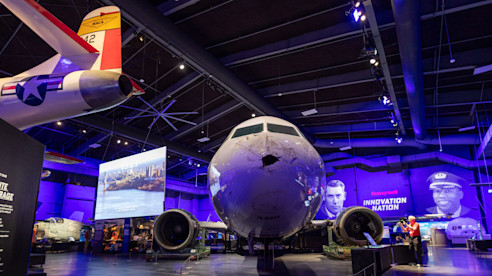 Exhibit at Sullenberger Aviation Museum featuring the Miracle on the Hudson aircraft with impact damage and tribute display.