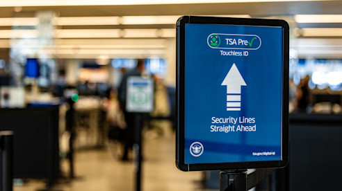 Un letrero de TSA PreCheck indica “ID sin contacto” y que las filas de seguridad están al frente.