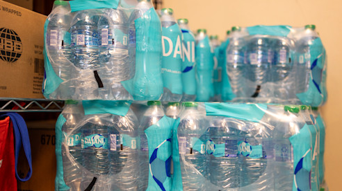 Cases of bottled water stacked on a storage shelf